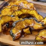 Crispy Roasted Acorn Squash in the Air Fryer 8 slices of cooked acorn squash on a wooden platter