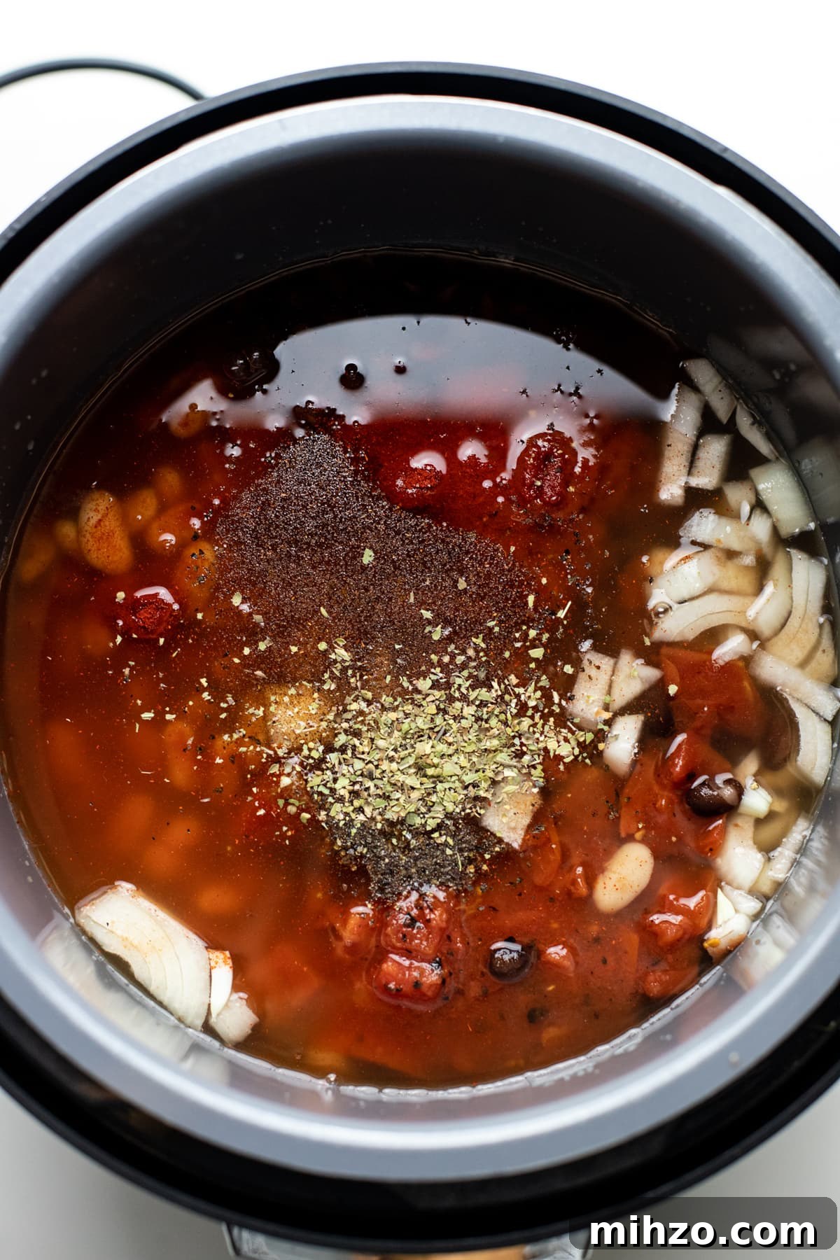 Slow-Cooker Chicken Chili Recipe for Cozy Weeknight Meals 5 A slow cooker pot with ingredients for chicken chili in it.