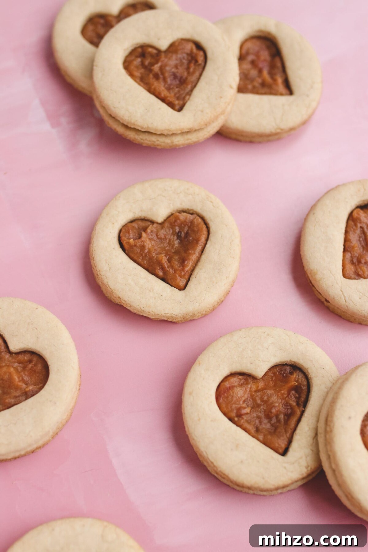 Vegan Gluten-Free Salted Caramel Cookie Recipe 5 heart shaped sandwich cookies on a pink background