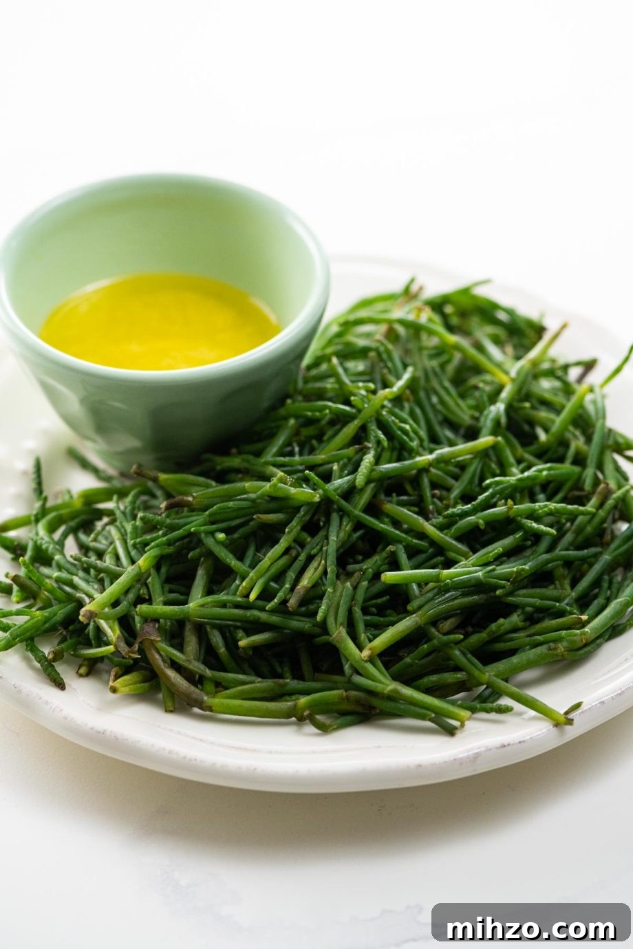 How to Cook Sea Beans (Samphire) — Simple Salicornia & Glasswort Recipe 6 sea beans on a plate with a bowl of lemon butter for dipping
