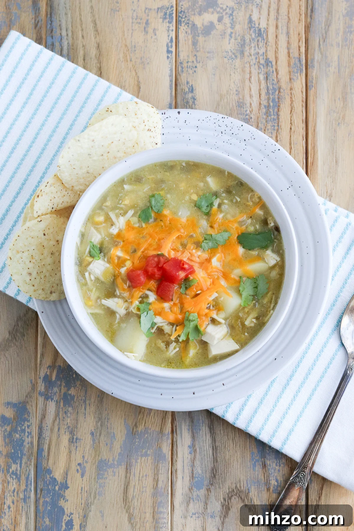 bowl of prepared green Chile soup with a side of tortilla chips