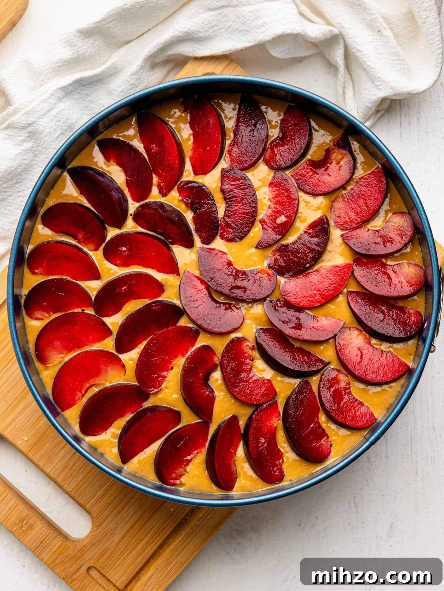 Yogurt plum cake in a cake tin before baking.