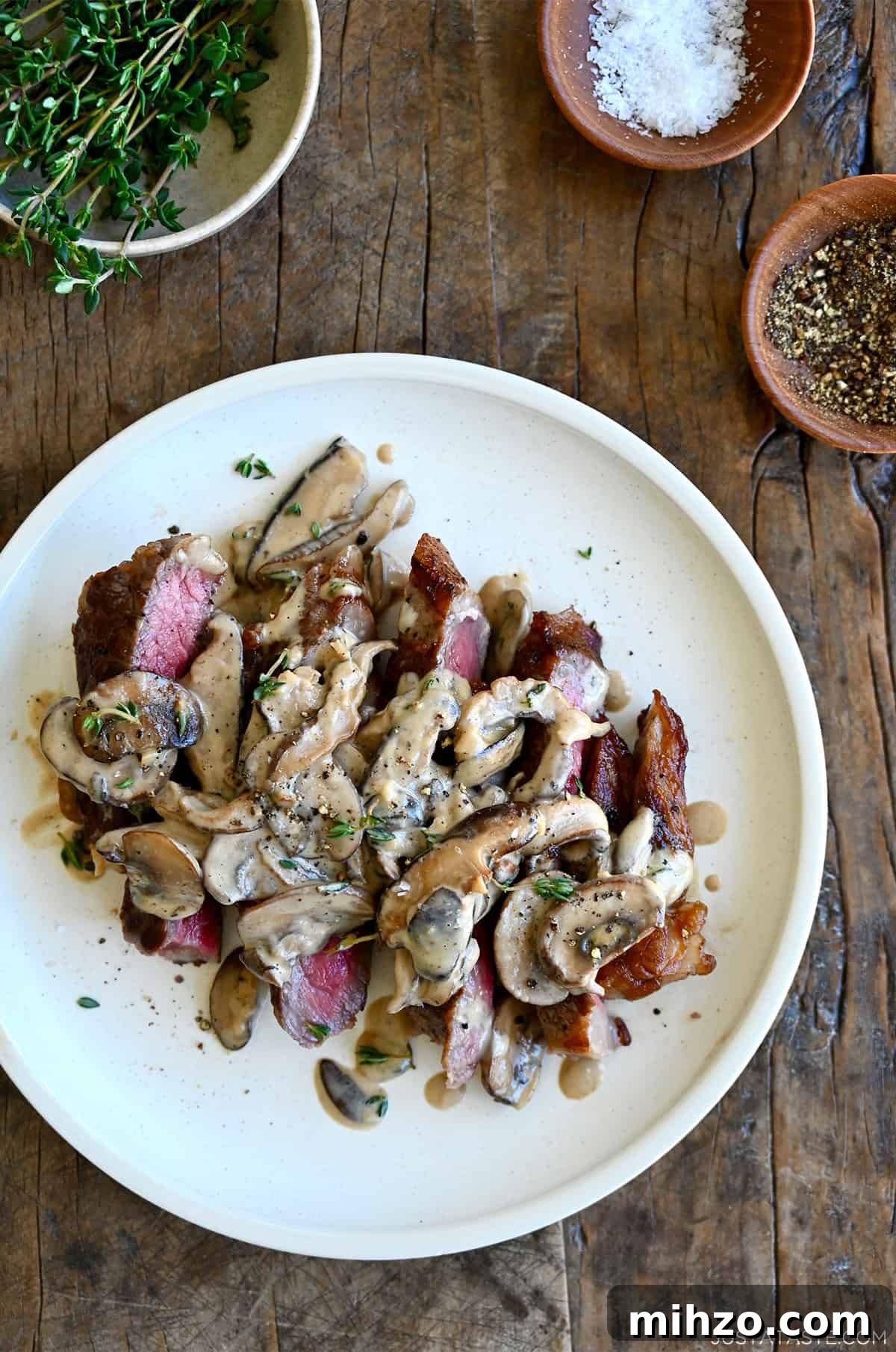 Creamy Garlic Mushroom Sauce for Pasta and Steak 10 Mushroom sauce over steak on a dinner plate.