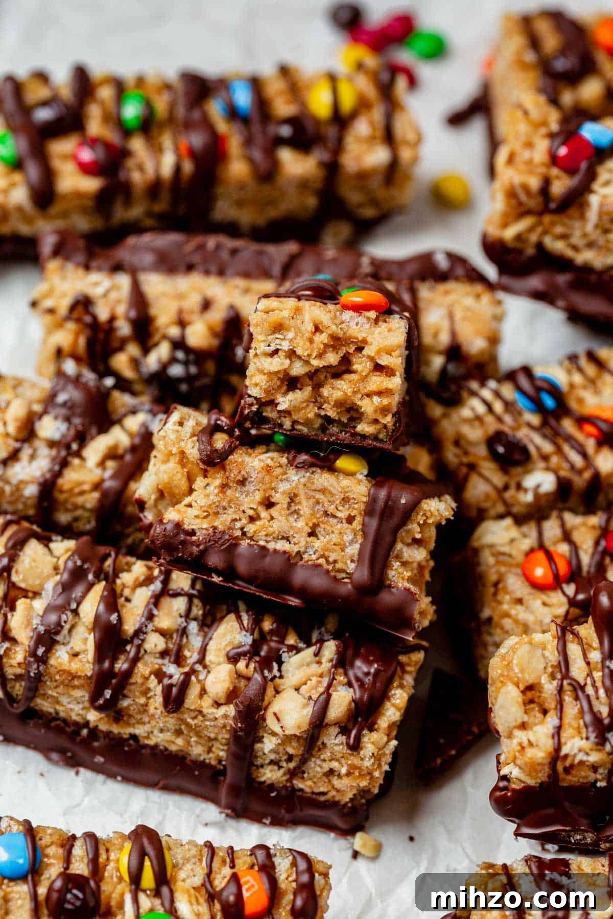 homemade kudos granola bar broken in half and stacked on top of a batch of bars.