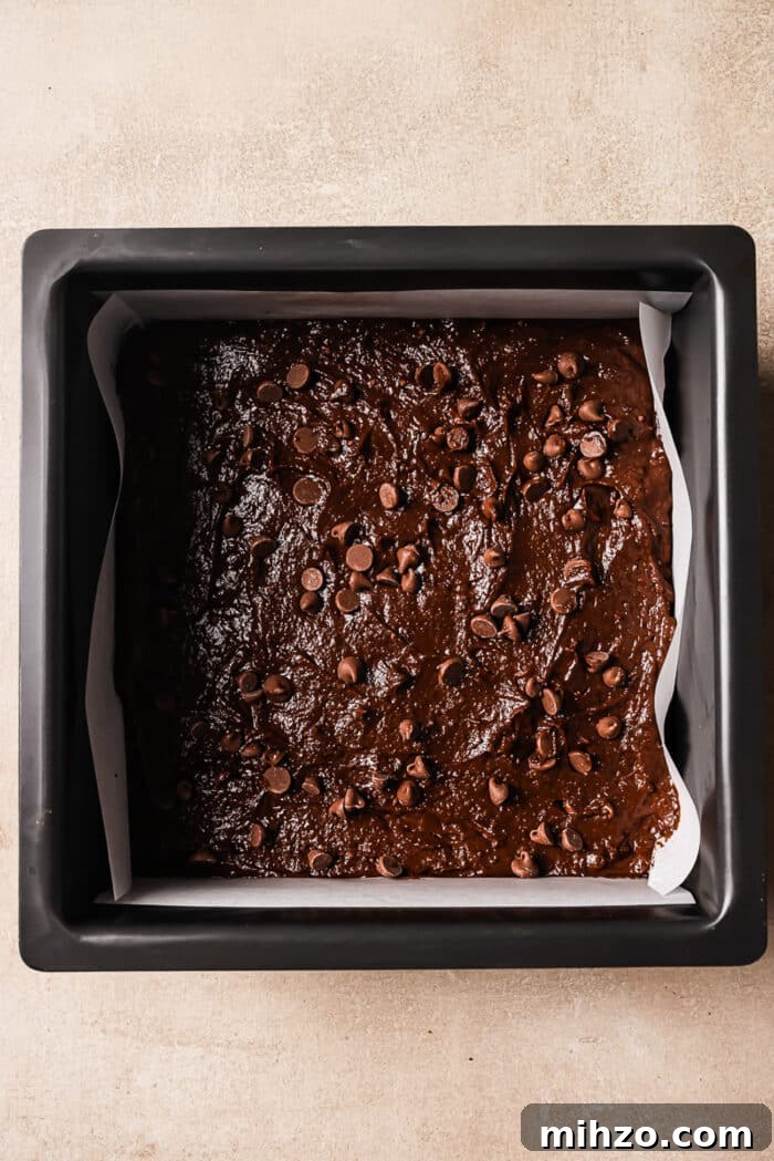 Fudgy Pumpkin Brownies with Warm Spice Flavor 6 An overhead view of brownie batter in a square pan.