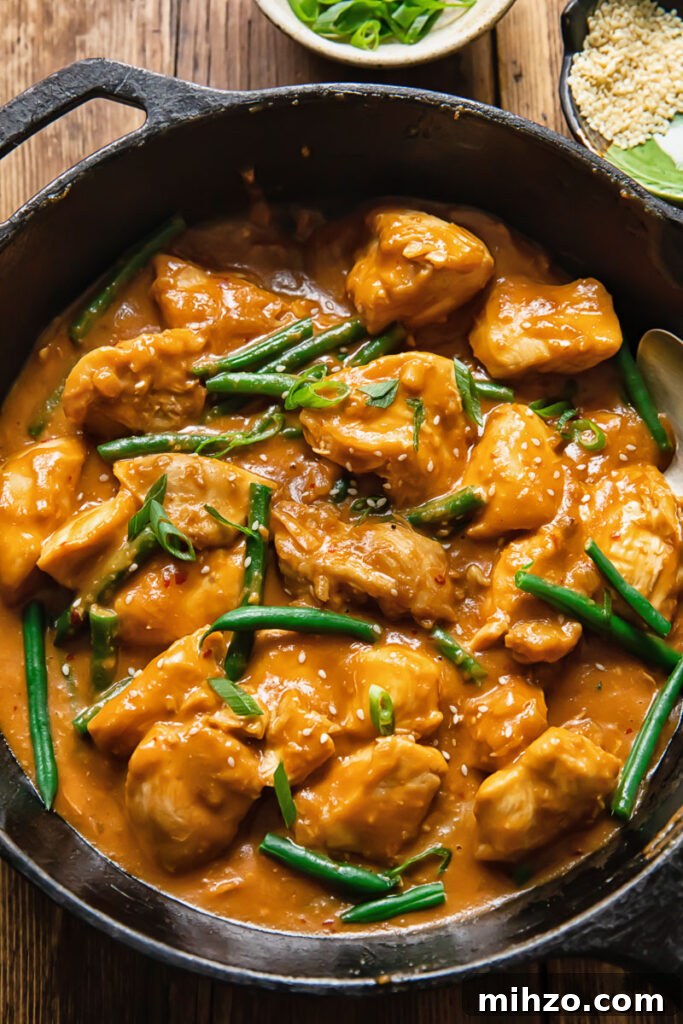 Top down shots of chicken and green beans with peanut butter sauce in a pan
