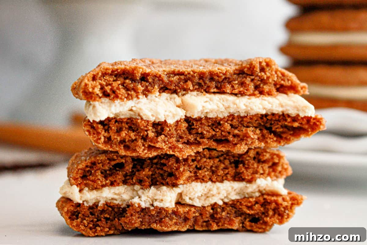 Gingerbread Sandwich Cookies Recipe for the Holidays 4 Halved gingerbread sandwich cookies in a stack. Gray background.