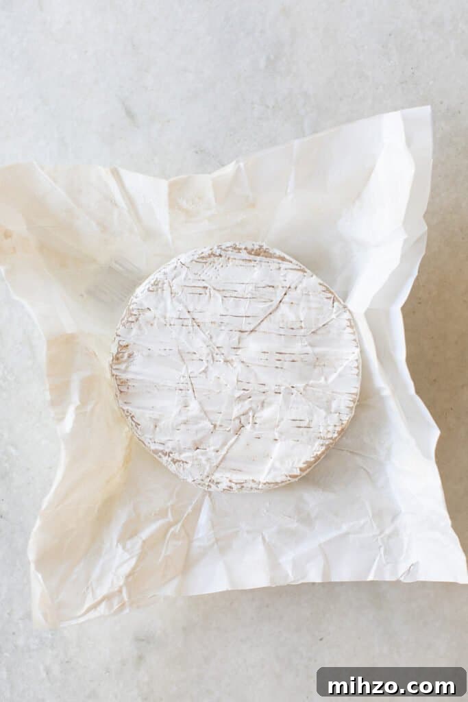 A Brie cheese wheel on parchment paper.