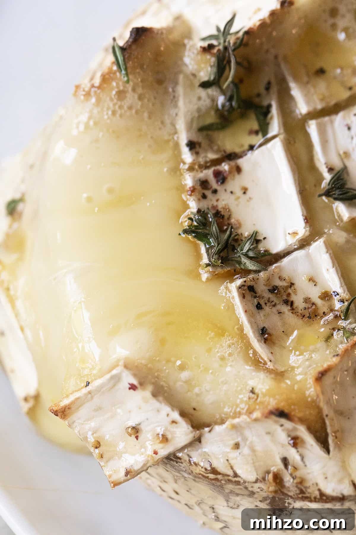 Melted baked brie cheese with herbs.