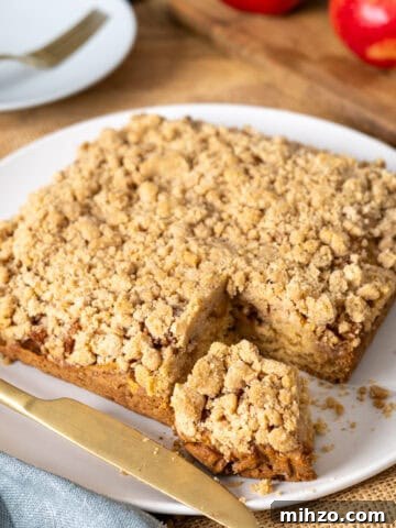 Zesty Lemon Blondies with Luscious Glaze 20 Applesauce crumb cake with a slice taken out on a white plate.