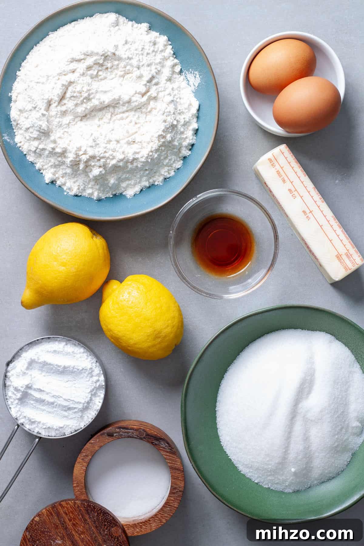 Zesty Lemon Blondies with Luscious Glaze 3 Ingredients for lemon and vanilla blondies on a gray table.