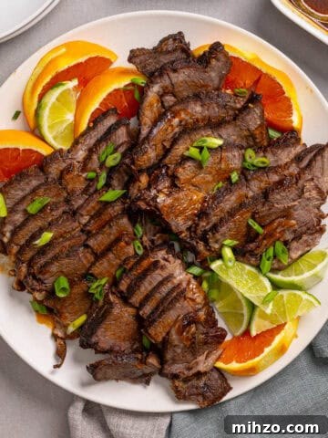 Zesty Lemon Blondies with Luscious Glaze 23 A close up of a platter with braised chuck roast sliced thin garnished with orange and lime.