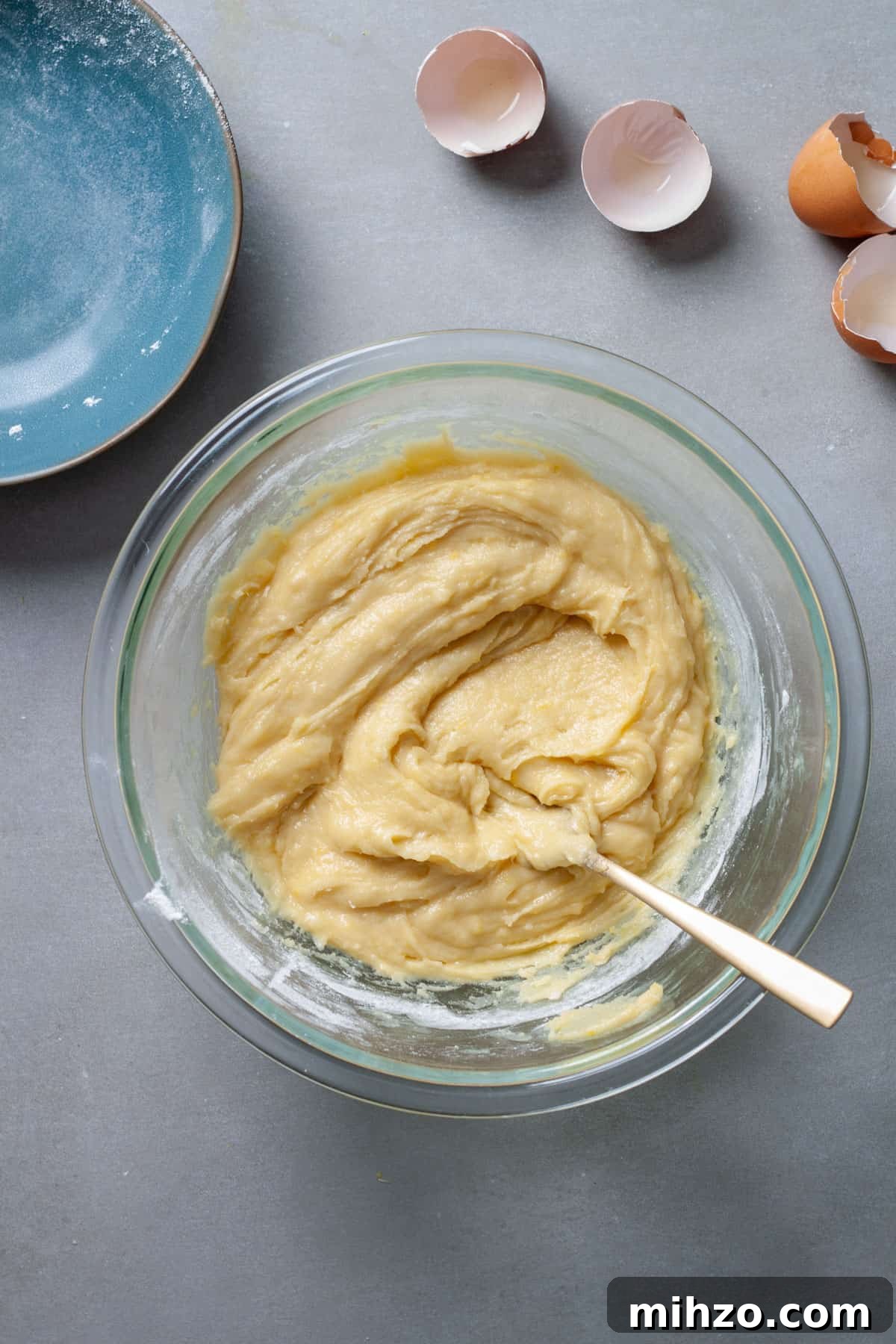 Zesty Lemon Blondies with Luscious Glaze 7 Lemon blondie batter in a glass bowl stirred together.