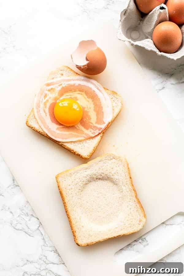 Crispy Bacon and Egg Toast Made in the Air Fryer 4 two slices of white bread one with bacon and raw egg on slice of white bread