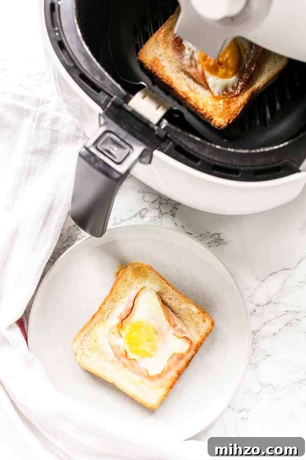 Crispy Bacon and Egg Toast Made in the Air Fryer 5 Egg toast with bacon on a white plate plus an Air Fryer and egg toast