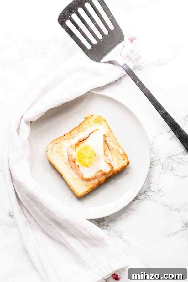 Crispy Bacon and Egg Toast Made in the Air Fryer 6 Egg toast with bacon on white plate