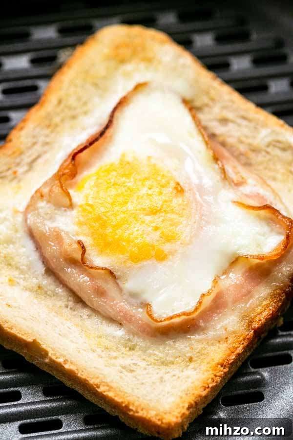 Crispy Bacon and Egg Toast Made in the Air Fryer 7 Egg toast with bacon on grill pan in Air Fryer basket