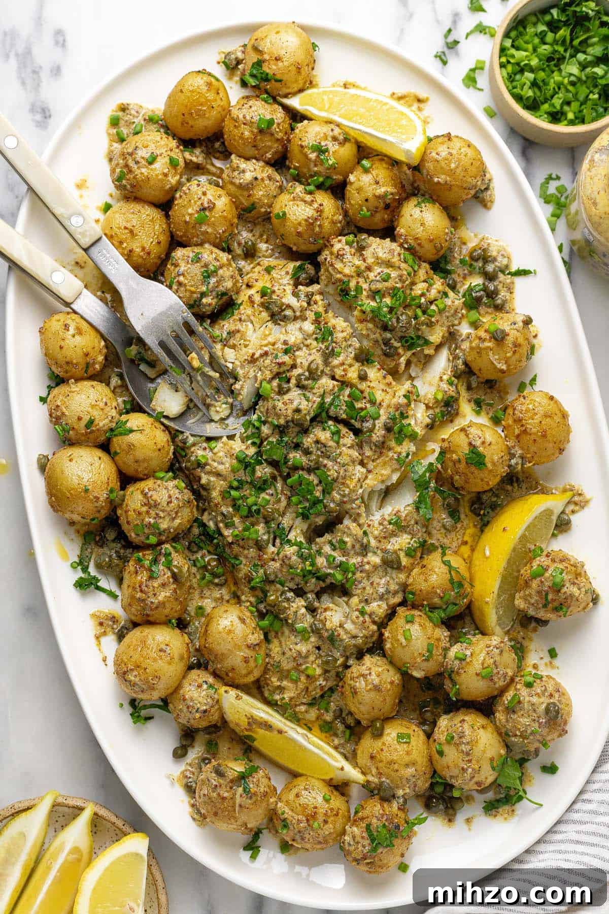 Oven-Baked Fish and Potatoes in Creamy Mustard Sauce 6 Serving platter filled with roasted potatoes and baked fish in mustard sauce.