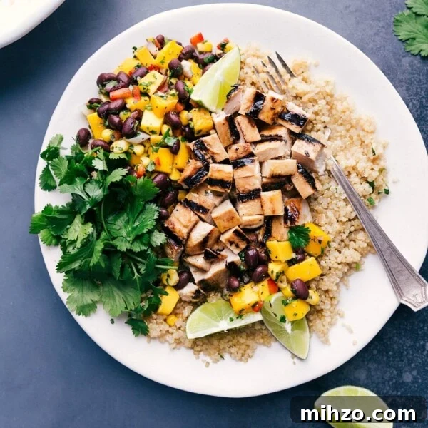 Delicious quinoa chicken bowl with fresh mango salsa and cilantro on the side.