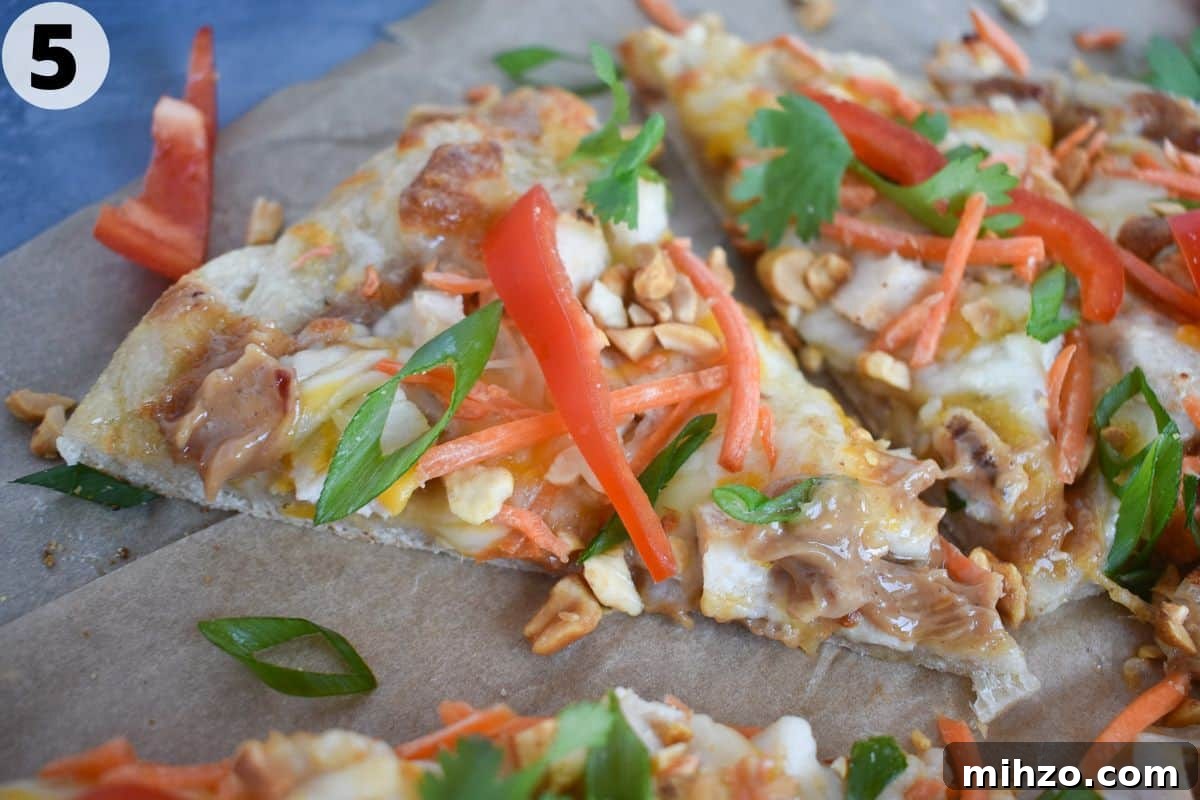 Thai Chicken Pizza Recipe: Tangy Peanut Sauce & Crispy Crust 6 slice of thai pizza on parchment paper.
