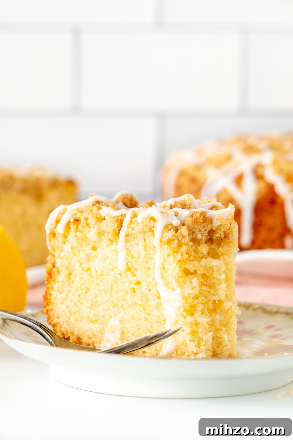 Lemon Coffee Cake Recipe — Moist Citrus Loaf for Brunch 10 Slice of lemon coffee cake with crumb topping with a bite taken out