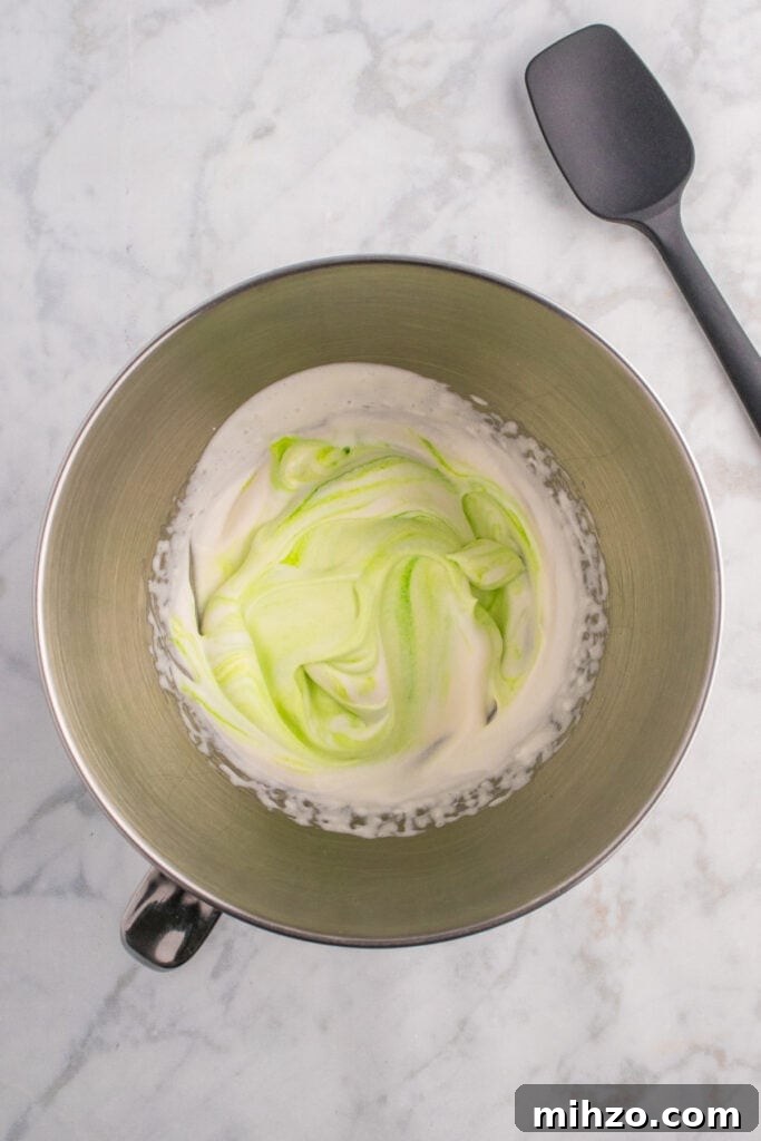 Toxic Waste Punch Recipe: How to Make a Neon Party Drink 11 Mixing bowl with swirled green and white whipped cream to create a toxic waste foam effect.