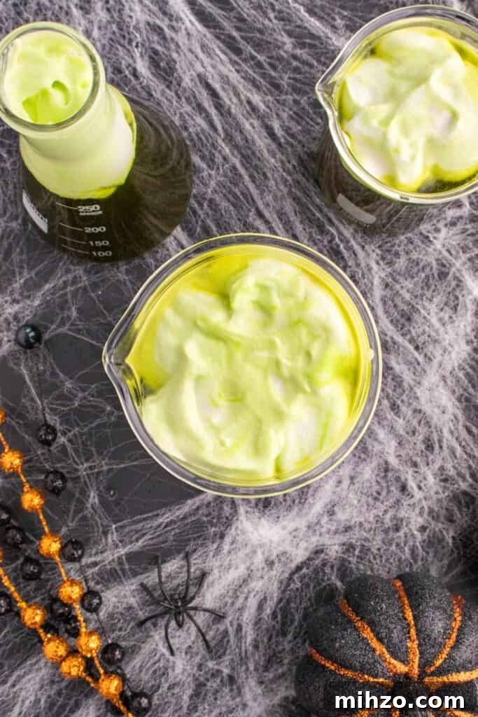 Toxic Waste Punch Recipe: How to Make a Neon Party Drink 15 Beakers of Toxic Waste Punch topped with green foamy whipped cream swirled on top for a spooky bubbling effect.