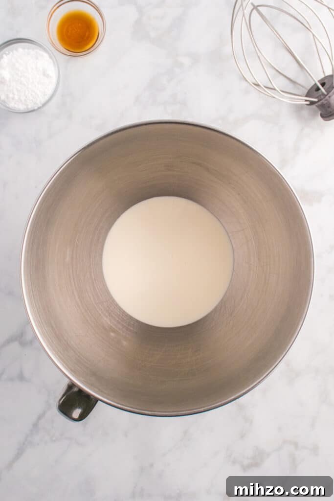 Toxic Waste Punch Recipe: How to Make a Neon Party Drink 8 Mixing bowl with heavy cream at the bottom, ready to be whipped with a whisk attachment and vanilla extract nearby.
