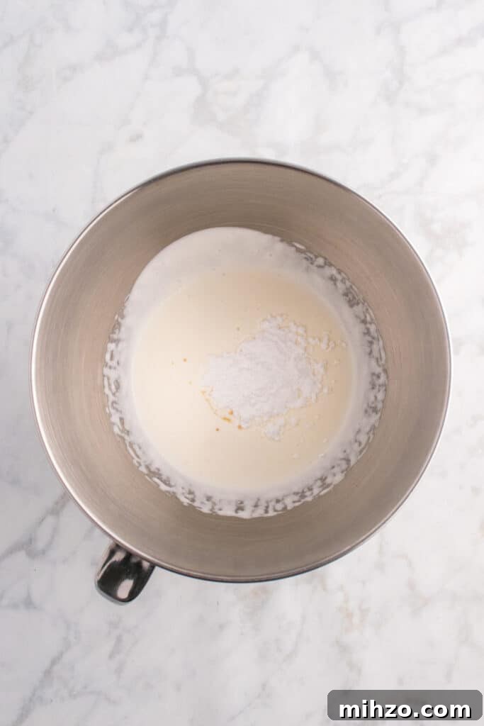 Toxic Waste Punch Recipe: How to Make a Neon Party Drink 9 Mixing bowl of whipped cream with powdered sugar and vanilla added on top, ready to be blended for toxic waste foam.