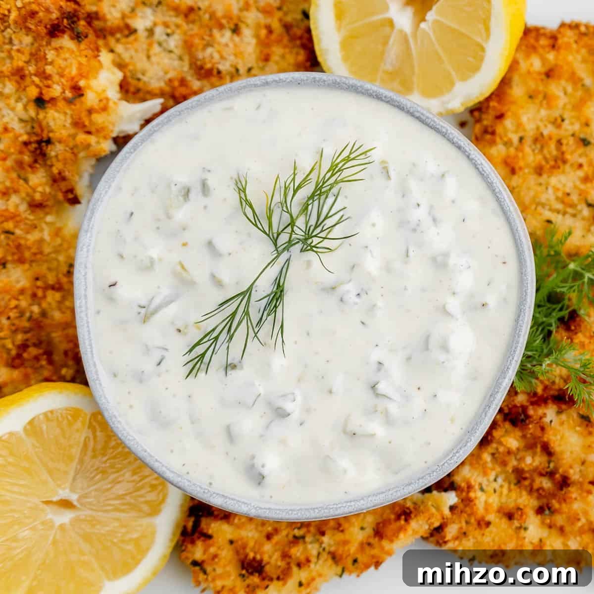 Creamy Homemade Tartar Sauce for Seafood 2 Overhead image of tartar sauce in a bowl with dill, lemon and surrounded by fish.