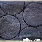 chocolate cake being cut out with cake rings on a sheet pan.
