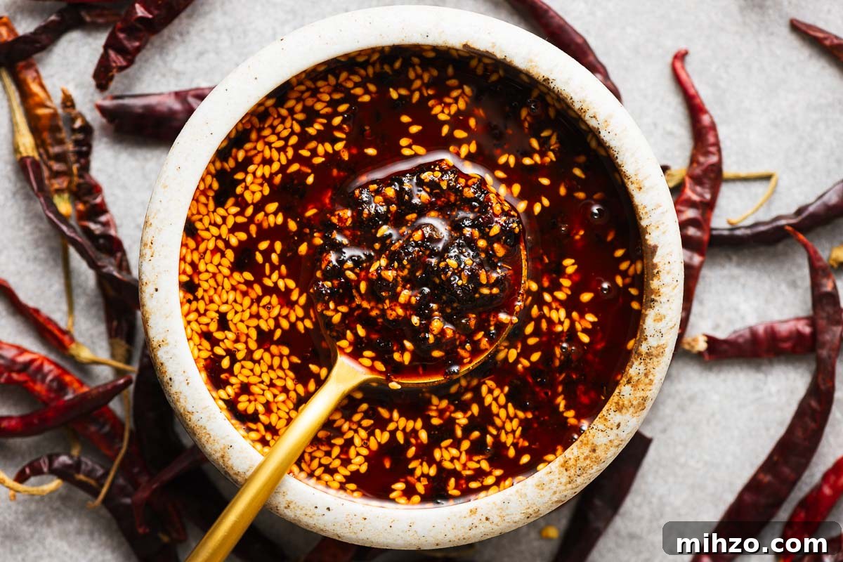 Homemade salsa macha in a small bowl surrounded by dried chiles.