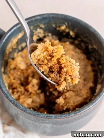A bite of banana bread mug cake on a spoon.