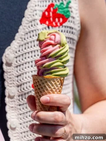Kayla Burton holding strawberry matcha ice cream in a sugar cone.