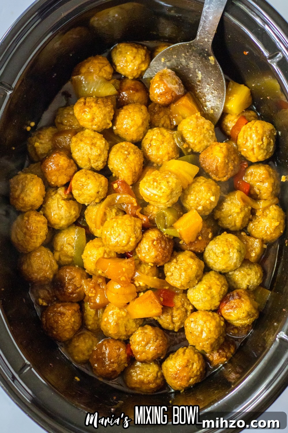 Slow Cooker Hawaiian-Style Pineapple Meatballs 3 cooked hawaiian meatballs in a slow cooker