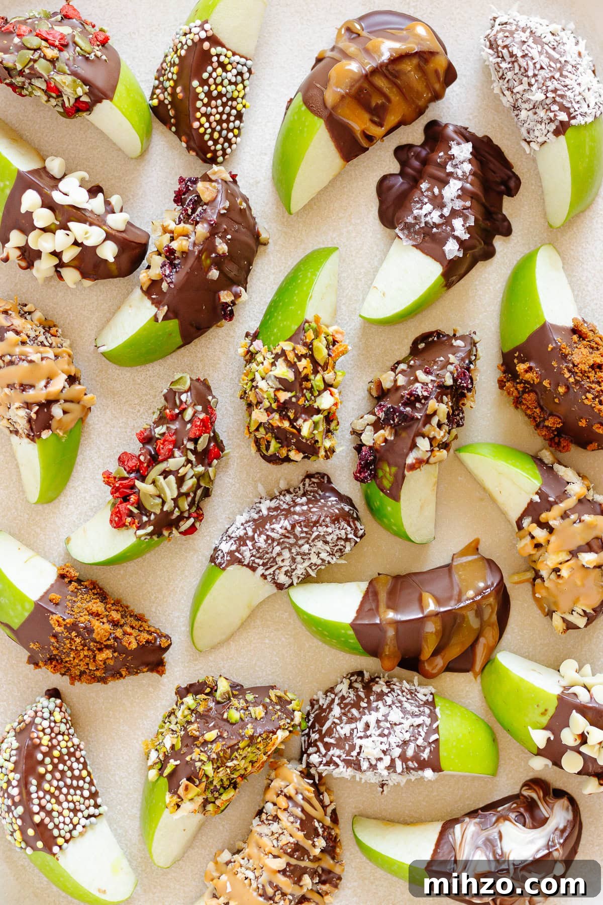 Chocolate-Dipped Apple Slices for Snacks & Parties 2 Chocolate apple slices dipped in a variety of toppings on a cream colored platter.
