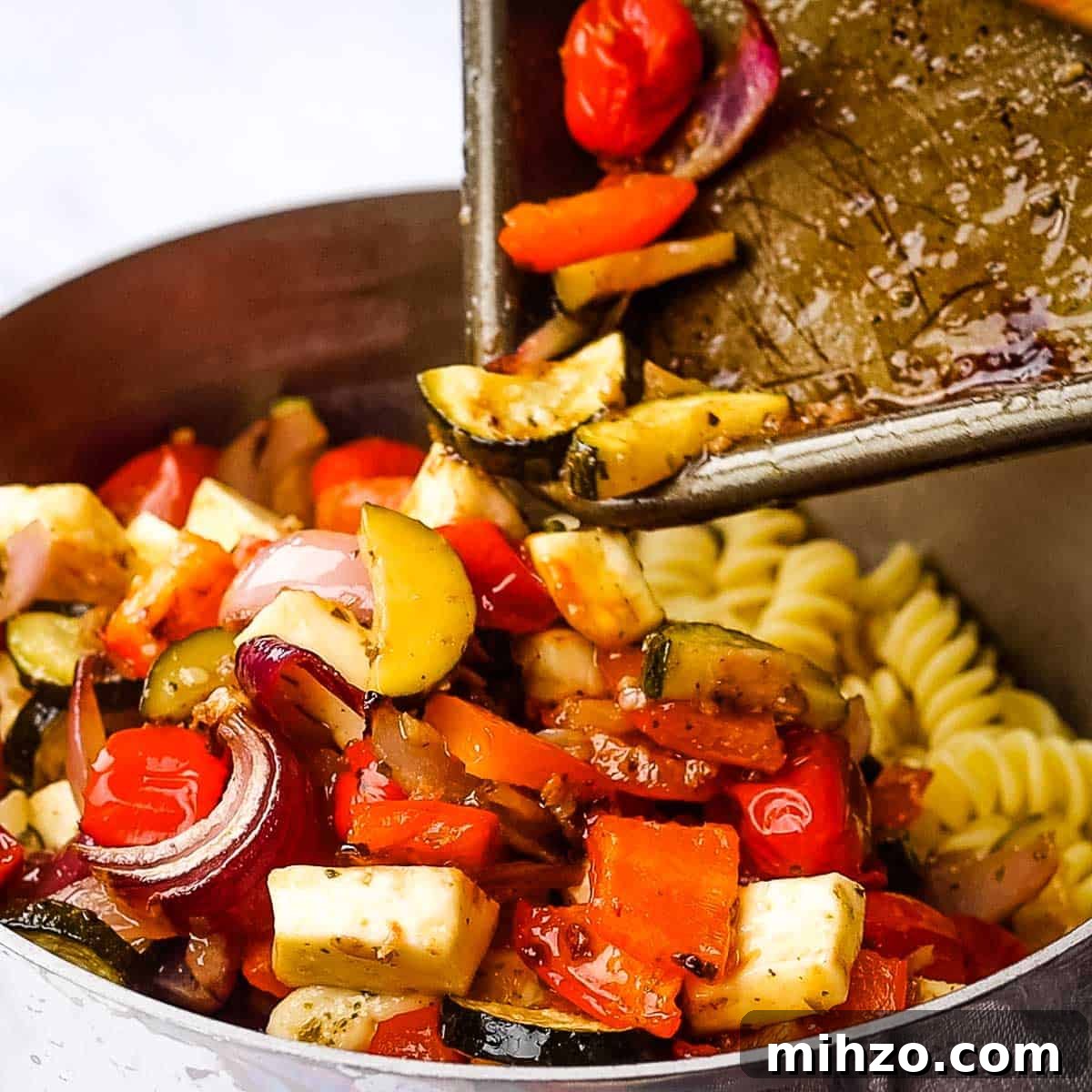 Creamy Halloumi Pasta with Cherry Tomatoes and Basil 11 roasted vegetables being added to drained pasta.