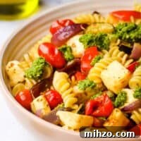 Creamy Halloumi Pasta with Cherry Tomatoes and Basil 14 A bowl of halloumi pasta garnished with pesto