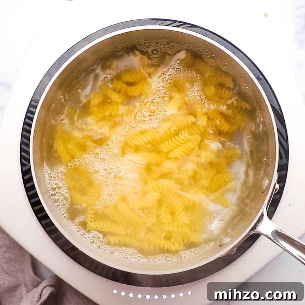 Creamy Halloumi Pasta with Cherry Tomatoes and Basil 8 Pasta boiling in a pot.