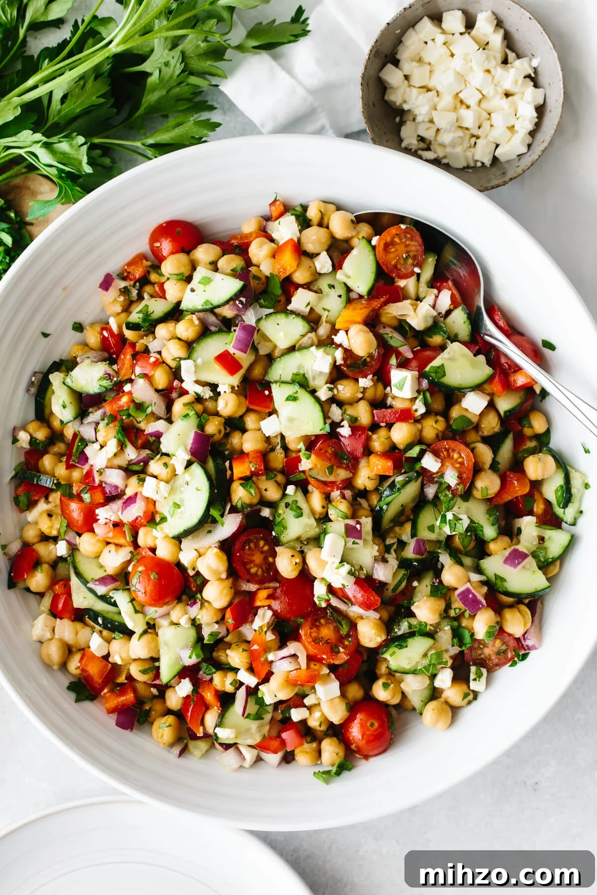 Mediterranean chickpea salad in a large white bowl on a table.