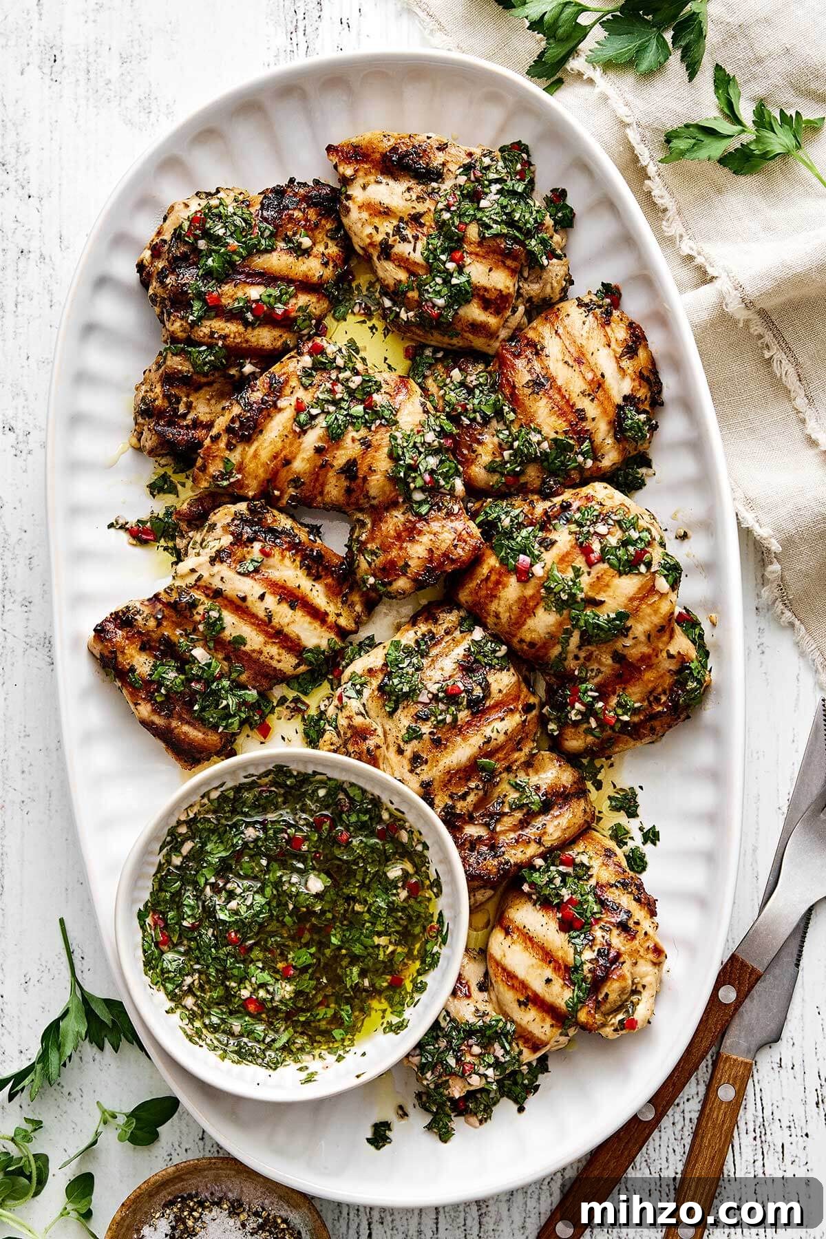 A plater of grilled chimichurri chicken thighs.