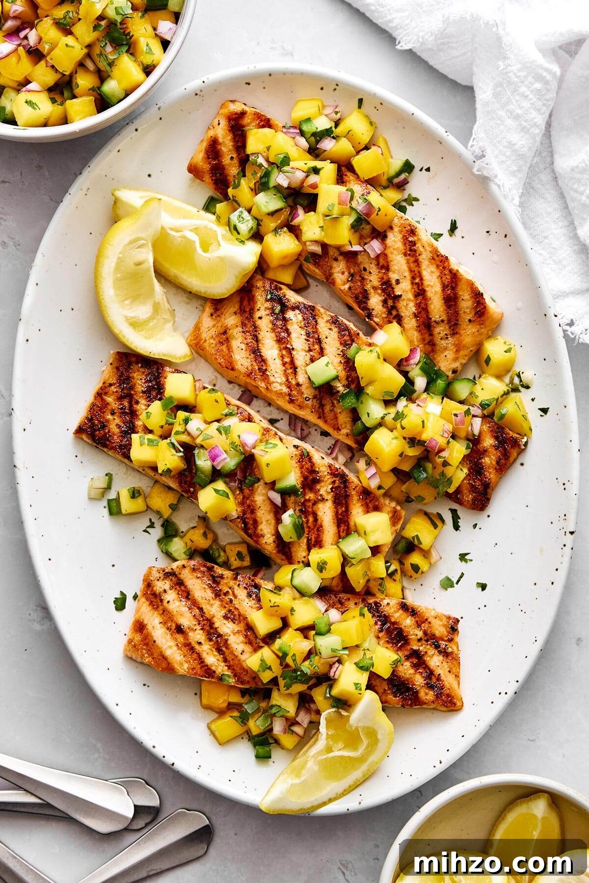 A platter of grilled salmon with mango salsa.