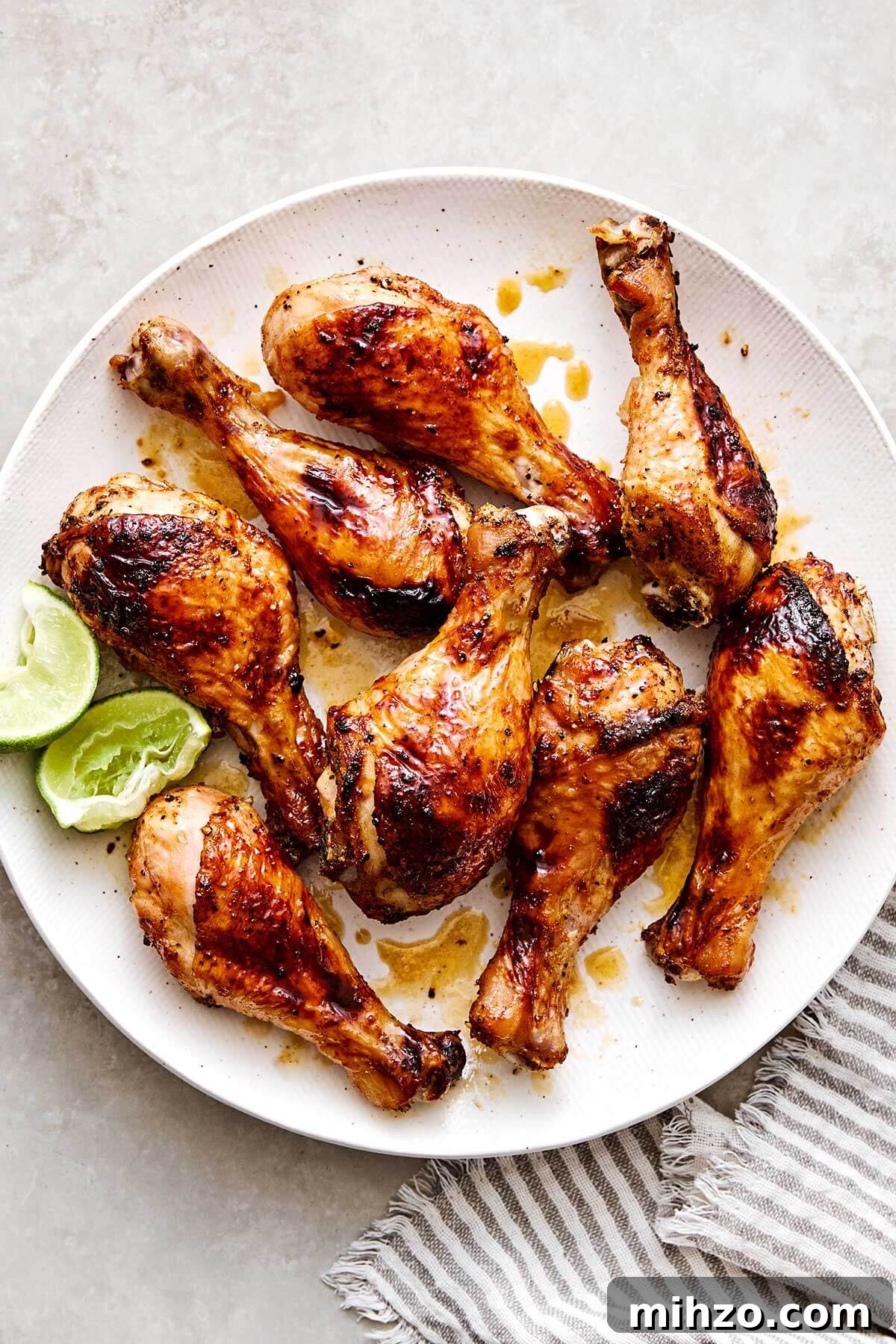 Hot honey chicken drumsticks with limes on a plate.