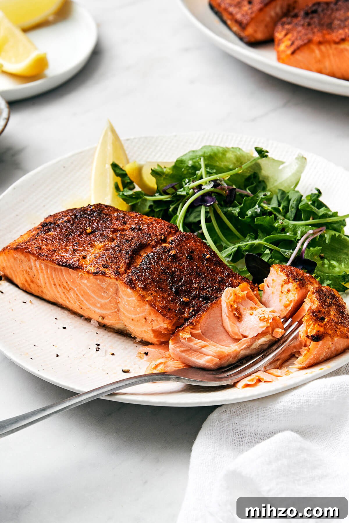 Air fryer salmon on a plate with a fork.