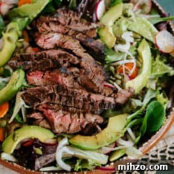 Grilled Carne Asada Steak Salad with Cilantro Lime Dressing 9 closeup shot of carne asada salad in a terracotta serving bowl.