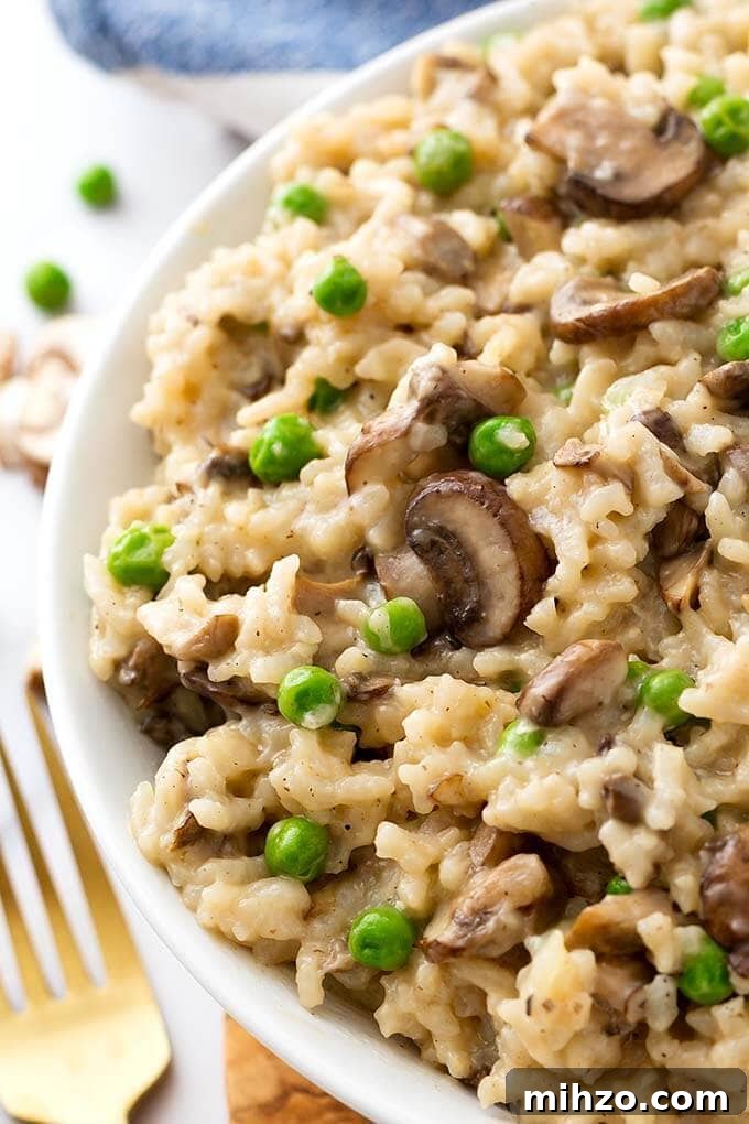 Creamy Instant Pot Mushroom and Pea Risotto 3 Closeup of Mushroom Risotto with Peas on a white plate