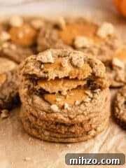 stack of pumpkin cheesecake cookies on parchment paper