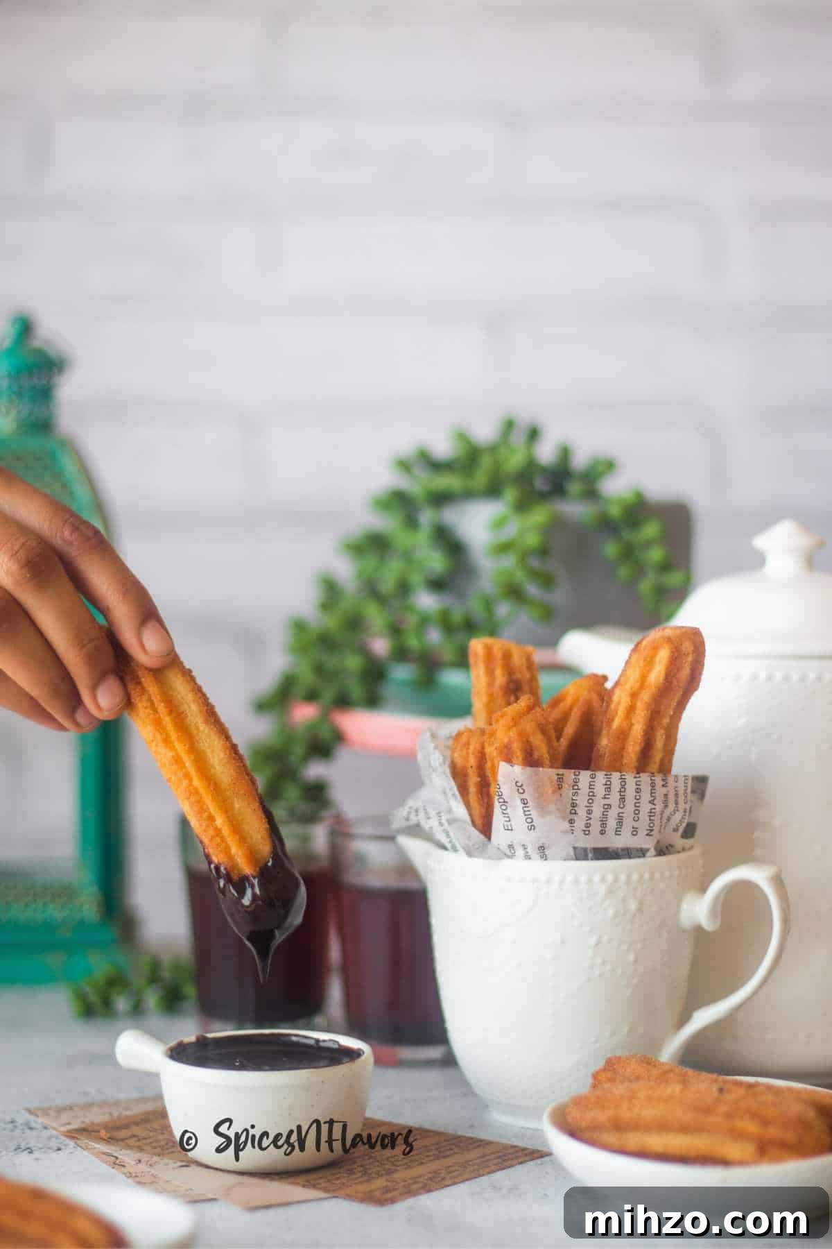 Crispy Eggless Churros Recipe: Step-by-Step Guide 2 eggless churros dipped in chocolate sauce with more plain churros kept in the background