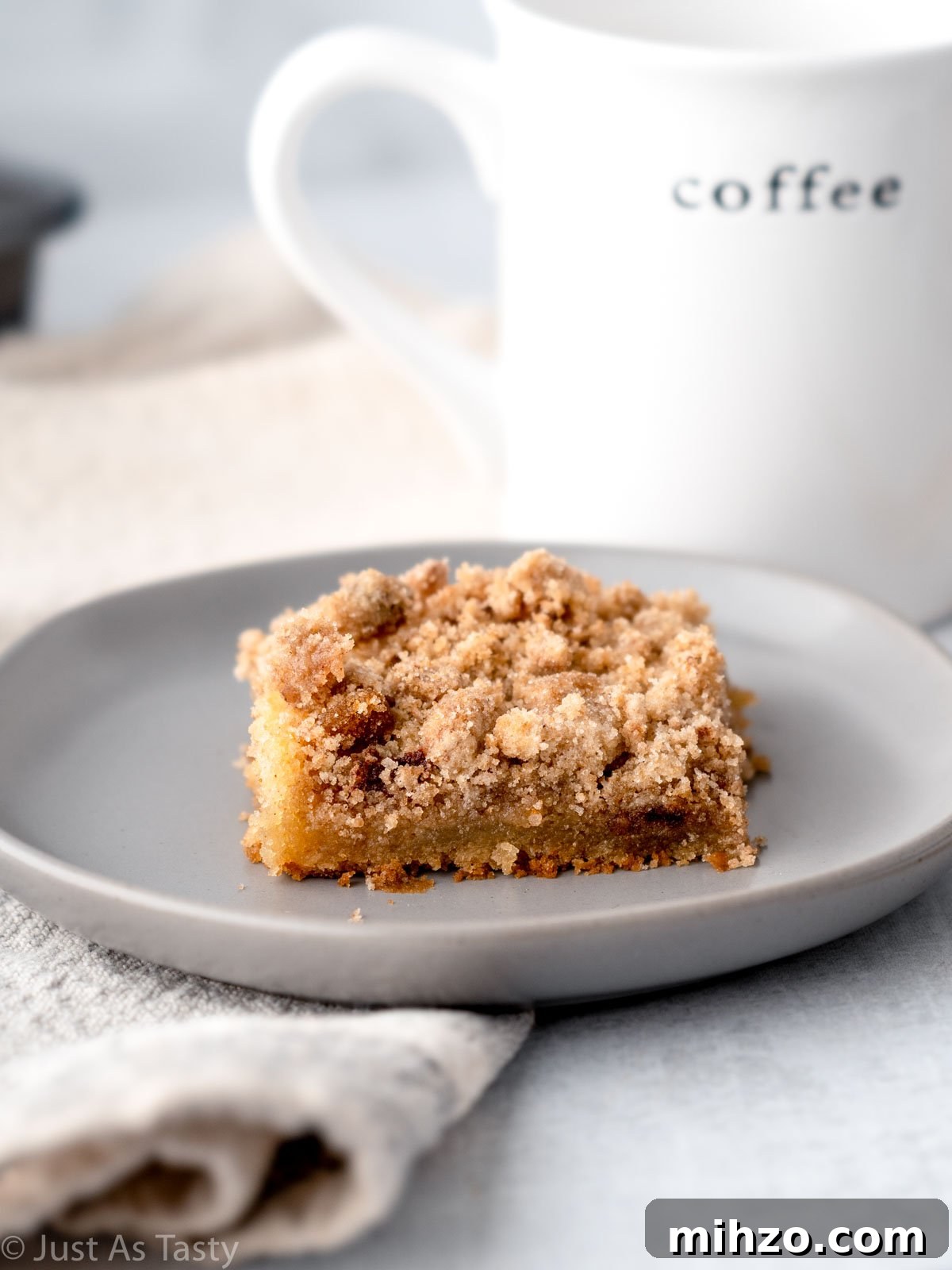 Eggless Coffee Cake with Cinnamon Streusel Topping 2 Slice of eggless coffee cake with streusel topping on a grey plate.