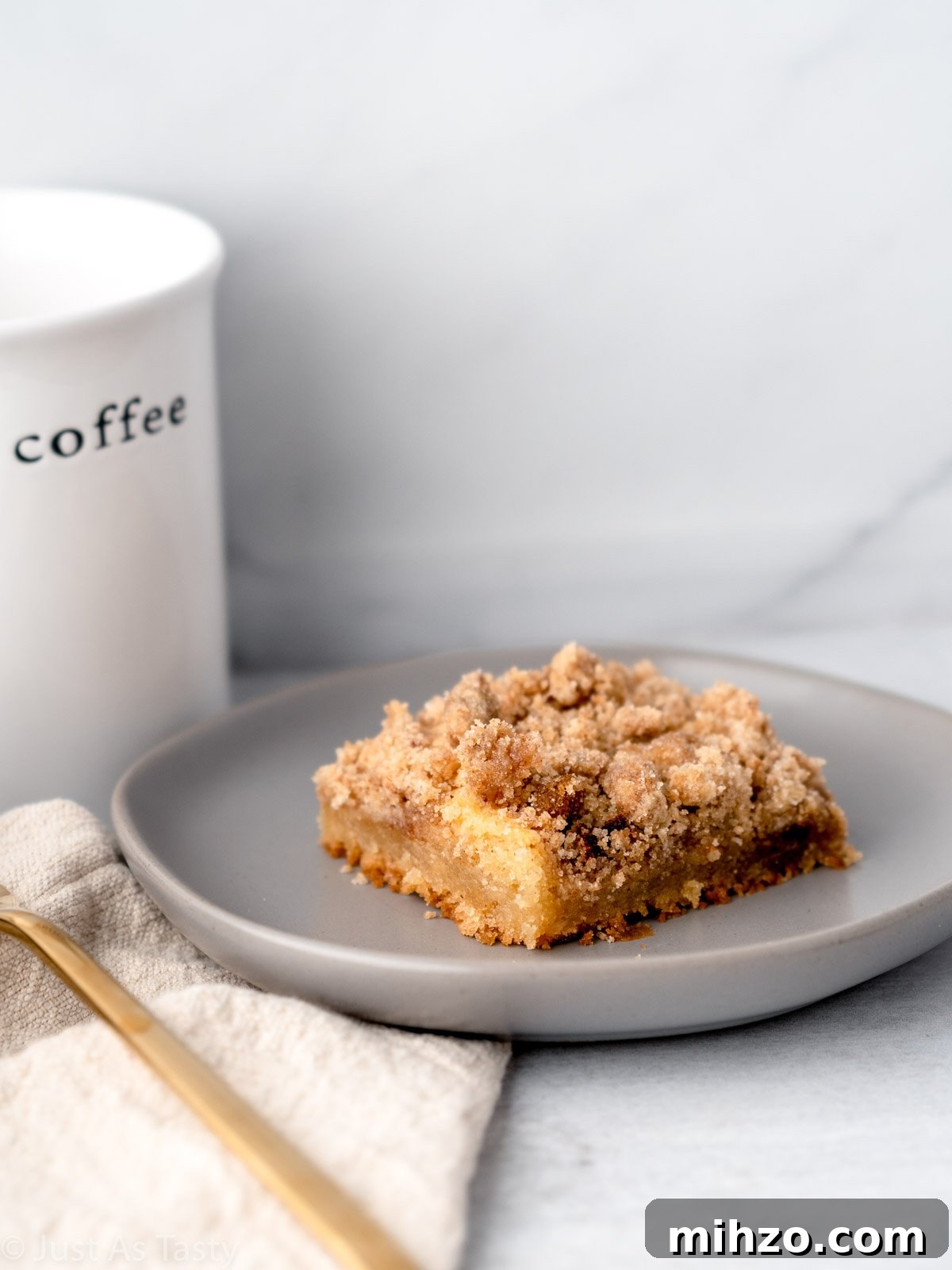 Eggless Coffee Cake with Cinnamon Streusel Topping 7 Close-up of a slice of coffee cake on a grey plate.